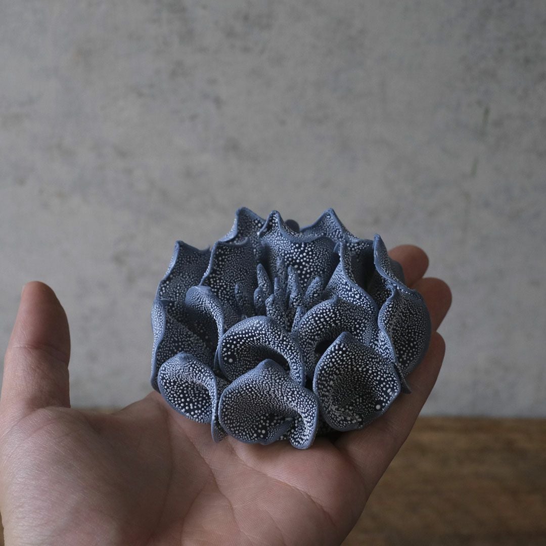 手のひらに乗せたABYSSALブルーの花のサイズ感と立体造形