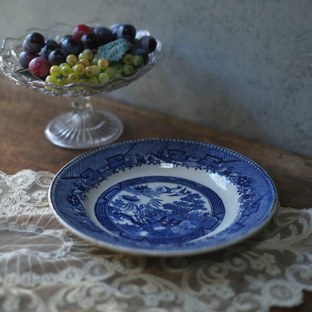 アンティーク ジアン ブルーウィロー プレート レースクロスとガラスコンポートを背景にした正面スタイリング写真
