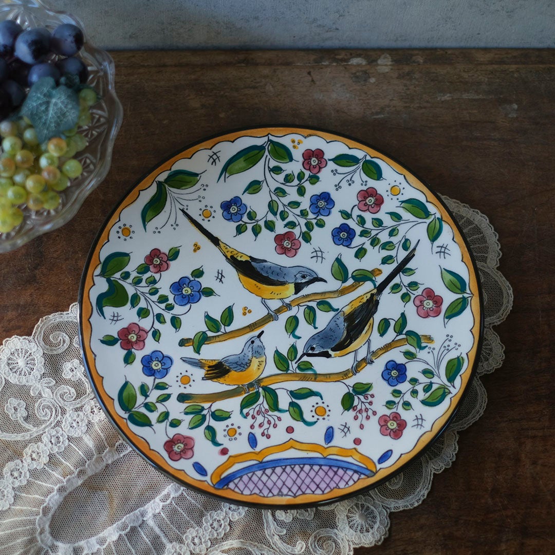 スペイン アンティーク手描き飾り皿 鳥と花の多色絵付け レースクロスとガラス器を背景にした俯瞰スタイリング写真