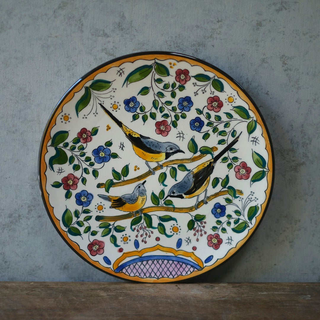 スペイン アンティーク手描き飾り皿 鳥と花の多色絵付け グレー背景に立てかけた正面全体像