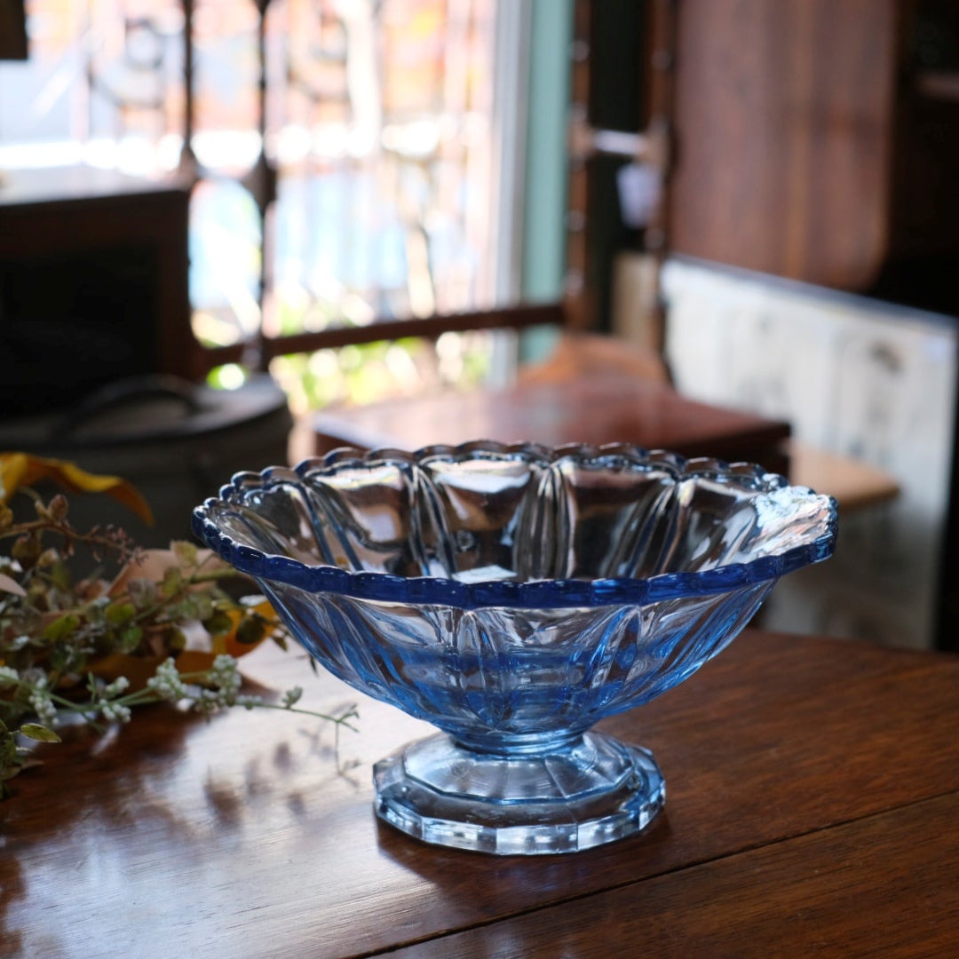 アンティーク ブルーガラス高台ボウル・斜め俯瞰・木製テーブルの上に置かれた全体像