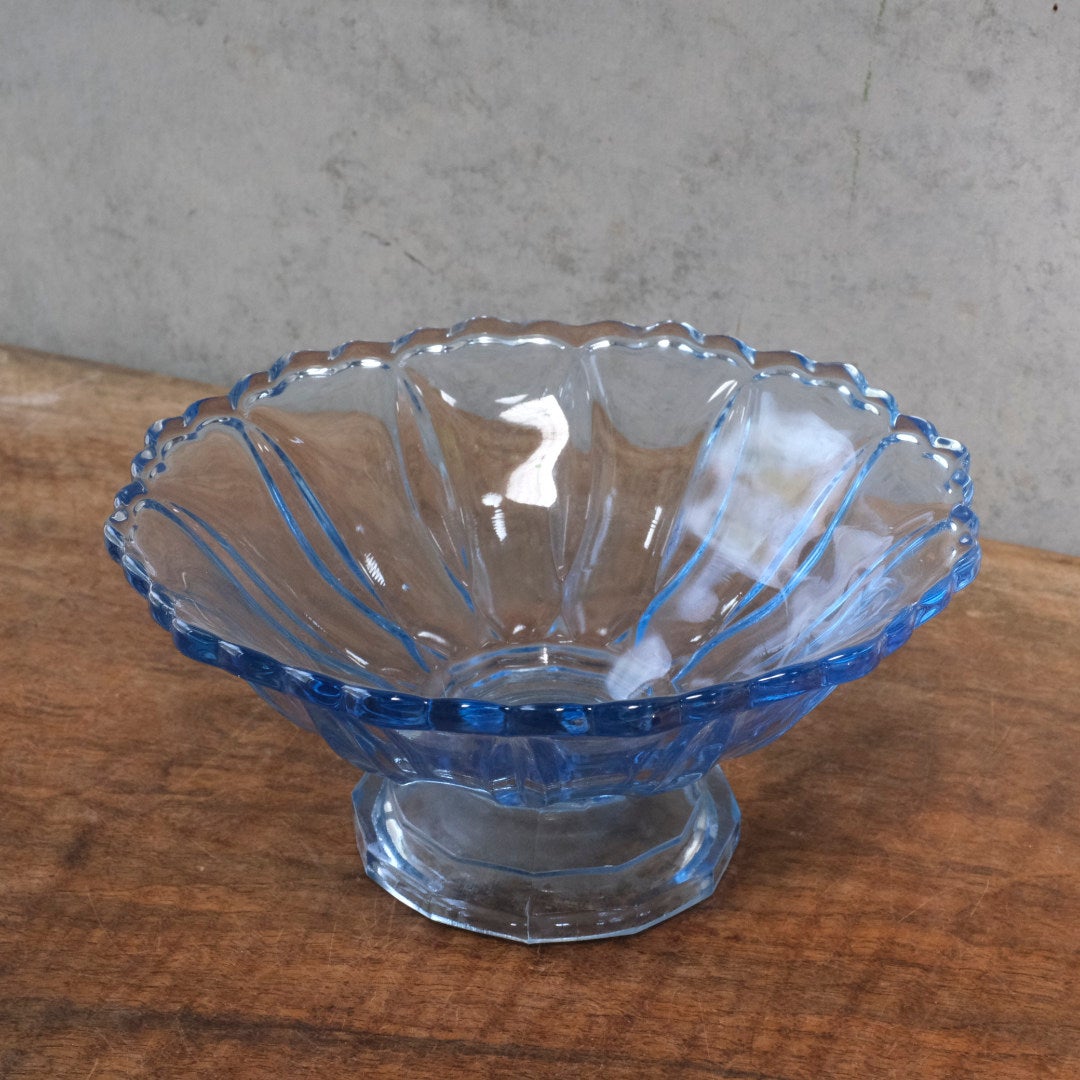 アンティーク ブルーガラス高台ボウル・斜め正面・木製テーブルの上に置かれたシンプルな全体像